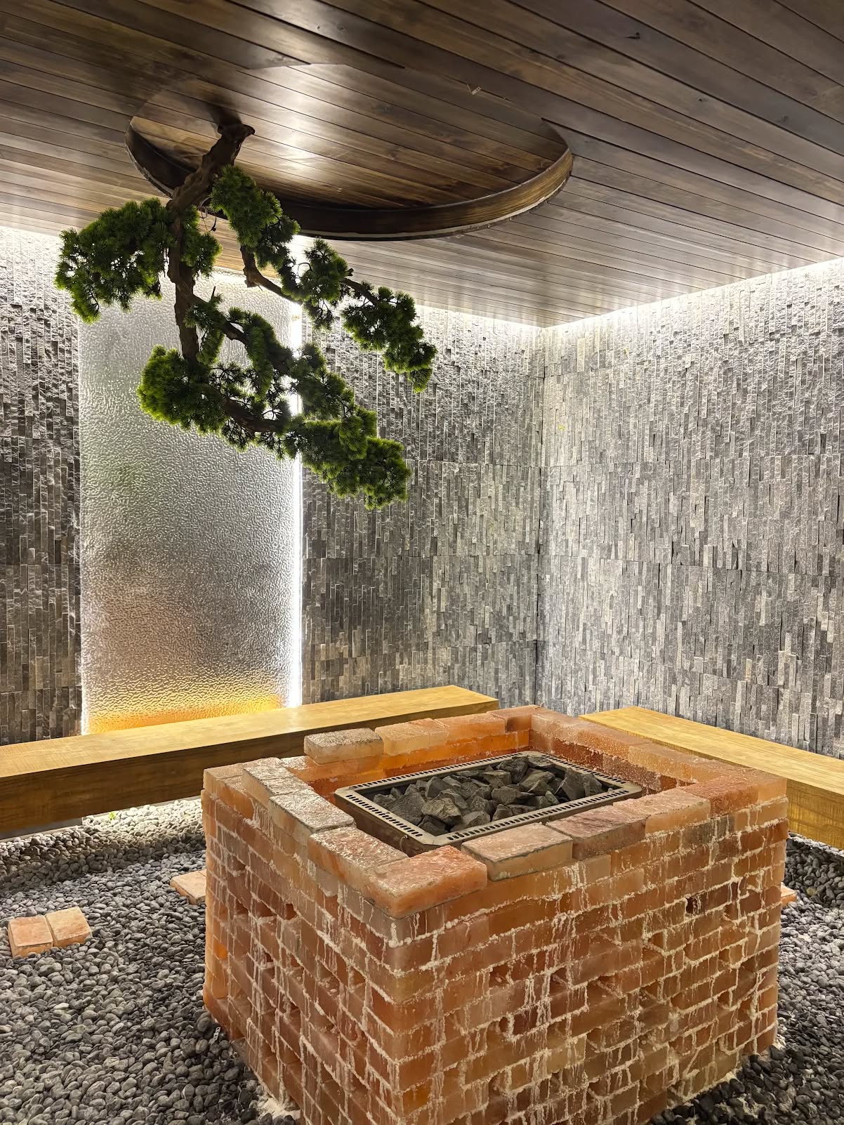 Japanese stone bath house with a salt brick hearth, water wall and bonsai