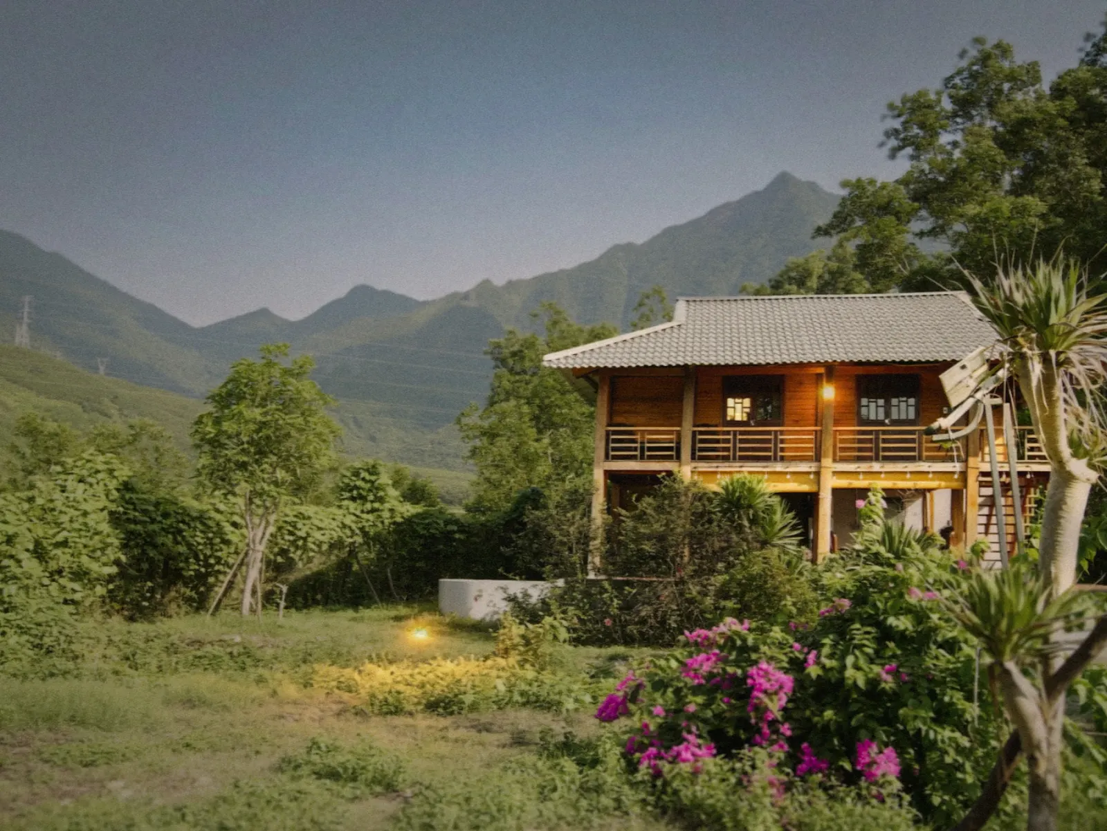 Villa nestled in greenery with misty mountains behind